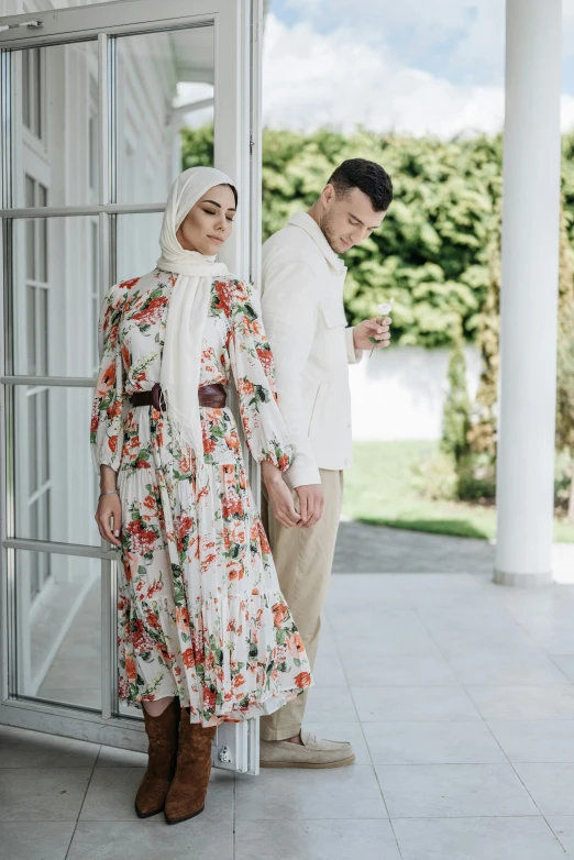 a man and a woman standing next to each other, inspired by Mihály Munkácsy, trending on pexels, modest flowing gown, islamic, porches, floral couture