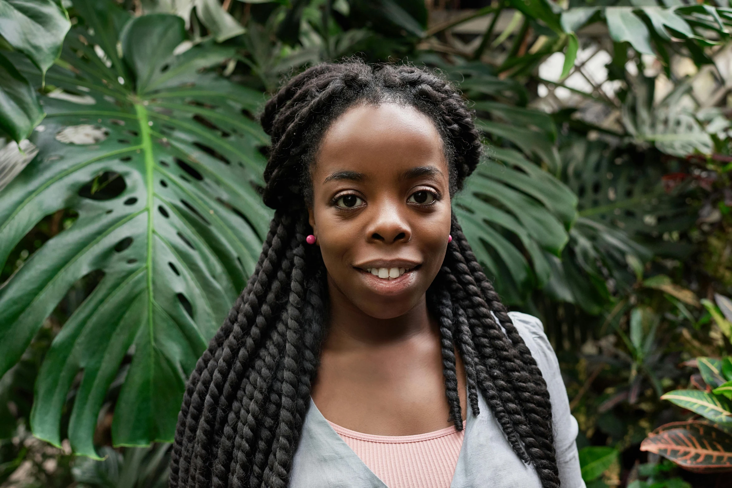 a close up of a person with long hair, inspired by Chinwe Chukwuogo-Roy, pexels contest winner, hurufiyya, standing in a botanical garden, headshot portrait, museum curator, thumbnail