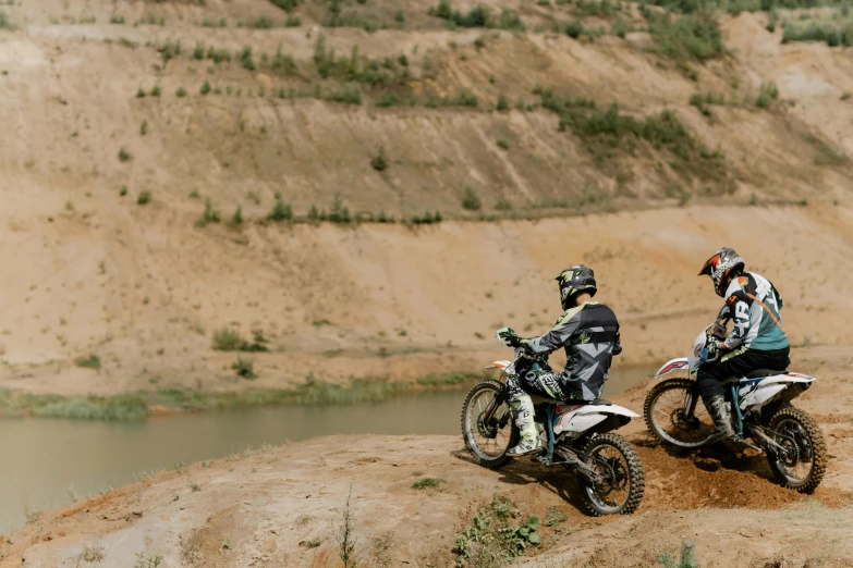 a couple of people that are on some dirt bikes, unsplash, figuration libre, low quality photo, near a river, 000 — википедия, geology