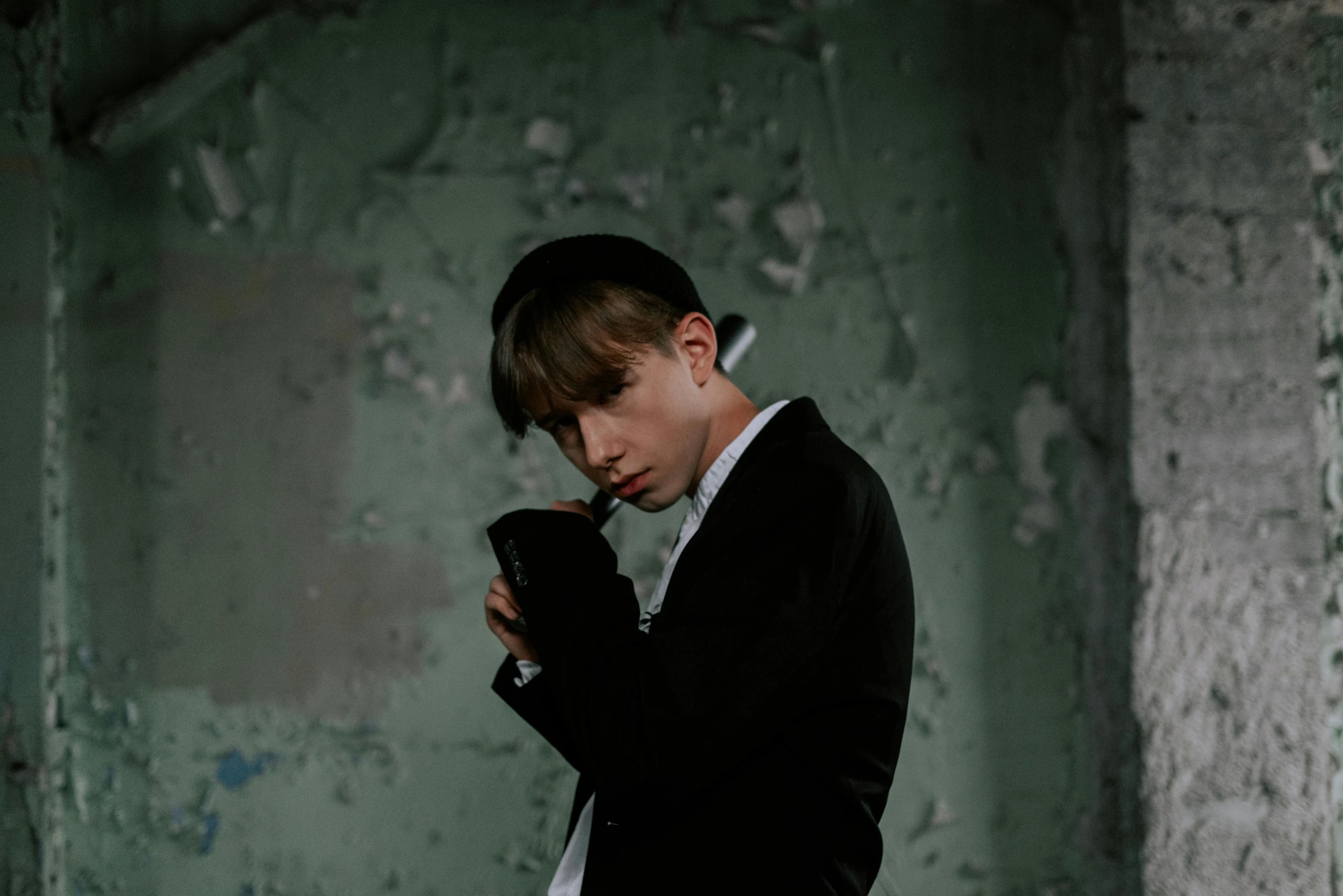 a boy in a suit holding a cell phone, by Emma Andijewska, pexels contest winner, graffiti, smoking pipe, plain background, portrait of 14 years old boy, androgynous