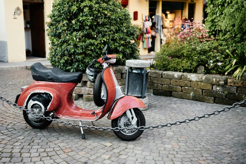 a red scooter parked on a cobblestone street, by Tom Wänerstrand, unsplash, auto-destructive art, chains, 1 9 6 0 s cafe racer, italy, 🚿🗝📝