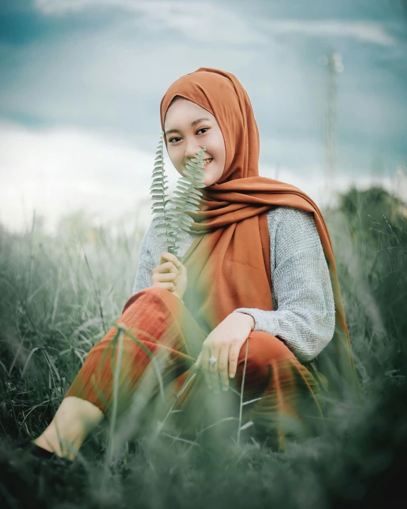 a woman wearing a hijab sitting in a field, a colorized photo, pexels contest winner, sumatraism, portrait image, chilling on a leaf, cute photo, ((portrait))