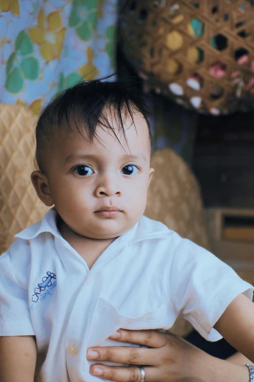 a woman holding a baby wearing a white shirt, an album cover, by Basuki Abdullah, pexels contest winner, young boy, looking serious, gif, ((portrait))