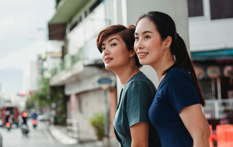 a couple of women standing next to each other on a street, pexels contest winner, nurse scrubs, japanese collection product, profile image, south east asian with round face