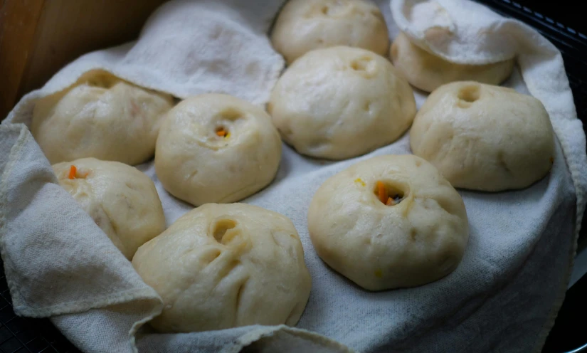 a basket filled with buns sitting on top of a table, inspired by Gu An, featured on reddit, sichuan, covered in white flour, passion fruits, closeup - view