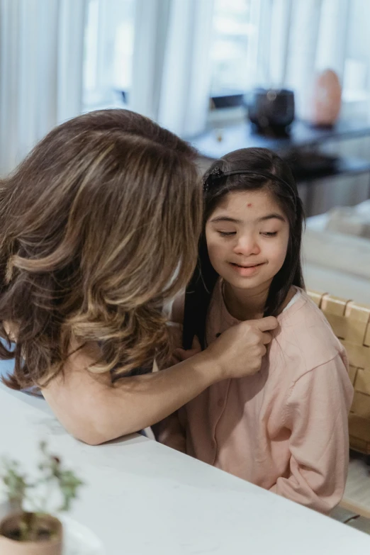 a woman standing next to a little girl at a table, by Lilia Alvarado, trending on pexels, beauty mark on cheek, hair floating covering chest, young asian girl, supportive