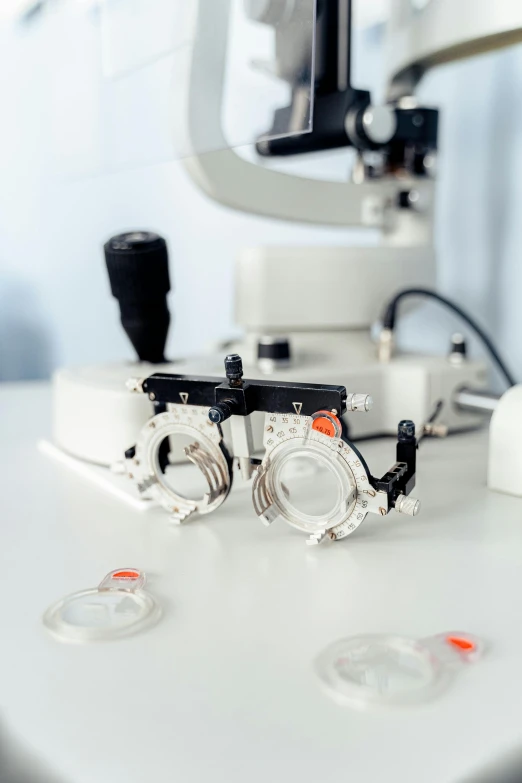 a pair of glasses sitting on top of a table, a microscopic photo, shutterstock, medical machinery, silver, aesthetics, uploaded