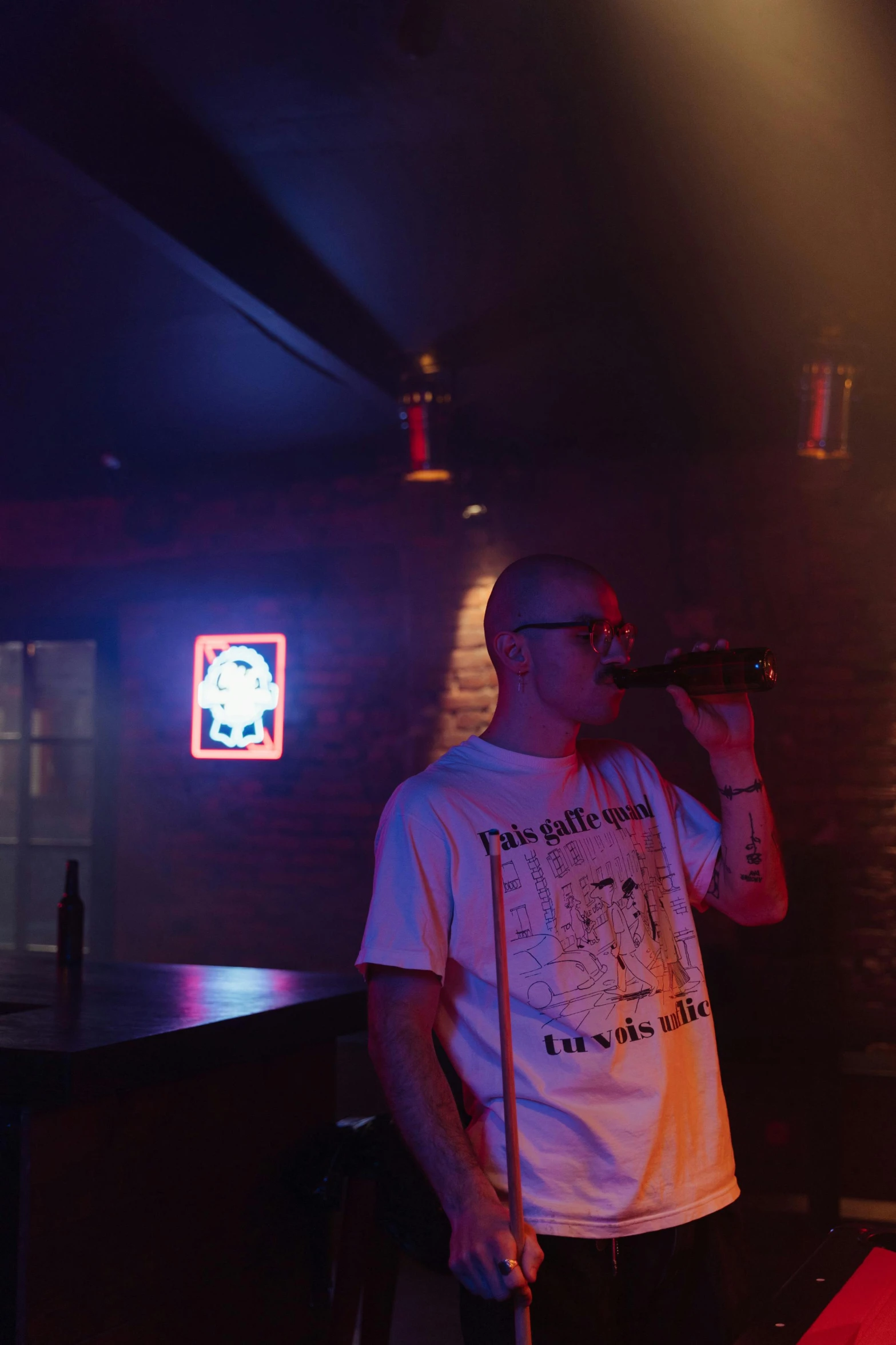 a man that is standing in front of a microphone, an album cover, by Dicky Doyle, unsplash, happening, drinking at the bar, shaved head, 2 rappers on stage at concert, in a pub