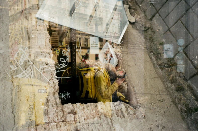 a newspaper is sticking out of a hole in a wall, a photo, by Nathalie Rattner, graffiti, with yellow cloths, transparent glass woman, cracked mirror, kacper niepokolczycki