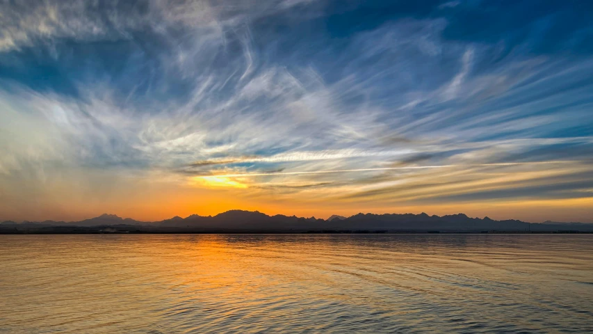 a large body of water with mountains in the background, by Niko Henrichon, pexels contest winner, romanticism, sunset + hdri, seattle, colorfull sky, image of the day