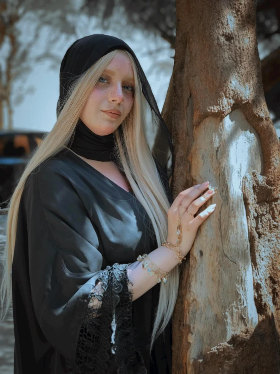 a woman that is standing next to a tree, an album cover, inspired by INO, renaissance, wearing black wizard robes, (12x) extremely pale white skin, ameera al-taweel, cosplay photo