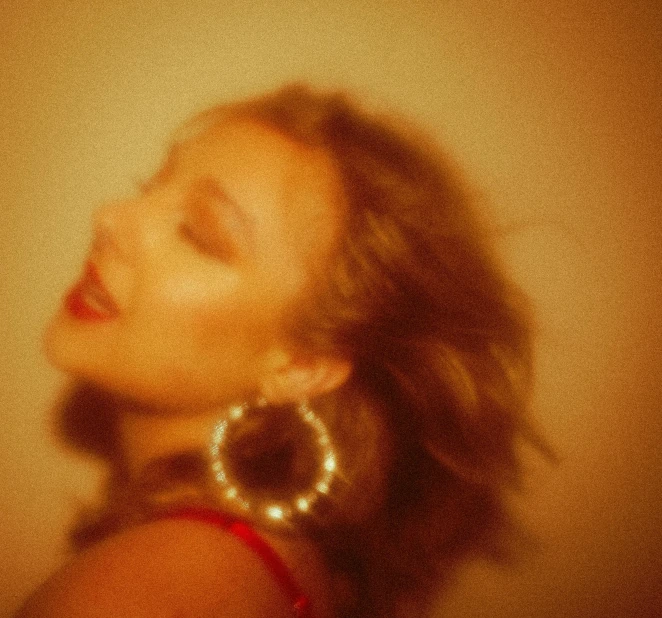 a close up of a woman with her eyes closed, an album cover, inspired by Elsa Bleda, trending on pexels, sydney sweeney, huge earrings, light leak, red