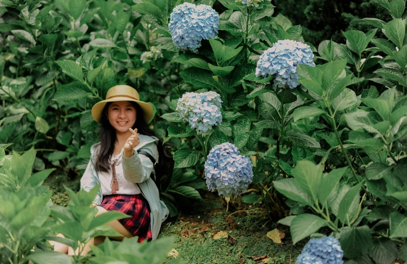 a little girl sitting in a field of flowers, inspired by Kim Jeong-hui, pexels contest winner, an isolated hydrangea plant, young asian woman, indonesia, standing in a botanical garden