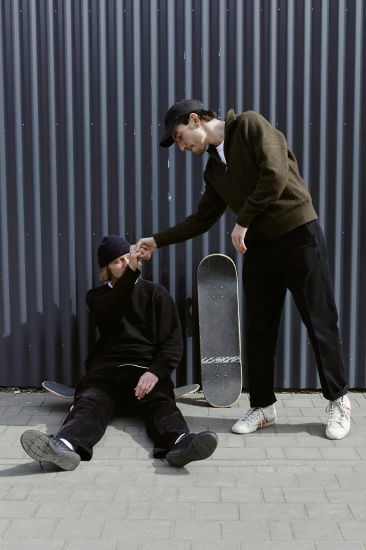 a man sitting on the ground next to another man with a skateboard, by Niko Henrichon, greeting hand on head, profile pic, concerned, lookbook