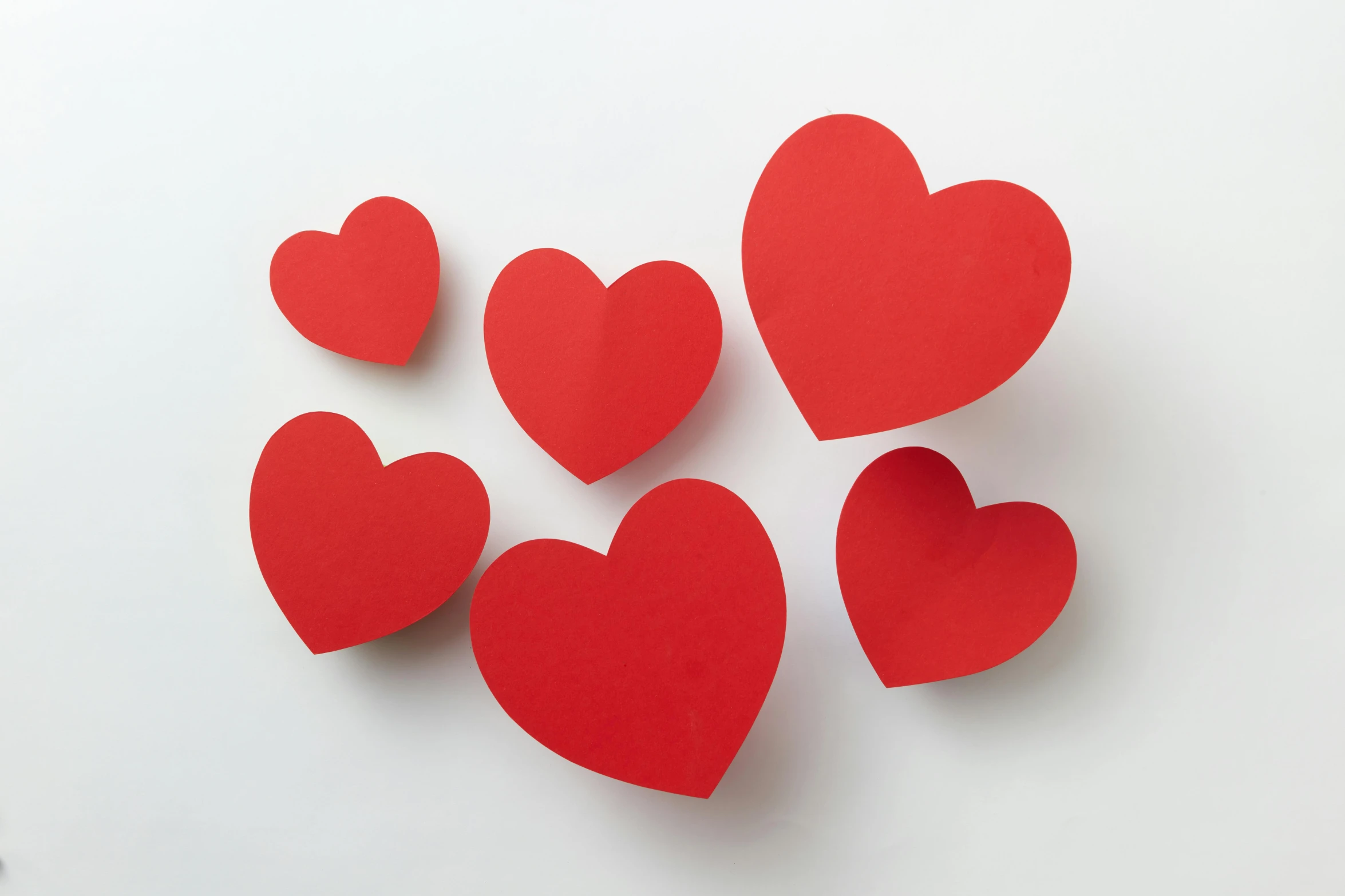 a group of red paper hearts on a white surface, pexels, jen atkin, in 3d, wall art, item