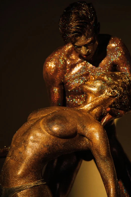 a bronze statue of a man wrestling a woman, a statue, trending on unsplash, figurative art, covered in crystals and glitter, shades of aerochrome gold, showstudio, taken in the late 2000s