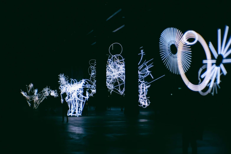 a group of people that are standing in the dark, an abstract sculpture, by Cerith Wyn Evans, pexels contest winner, interactive art, electricity archs, whirling, nebulous bouquets, wings made of light