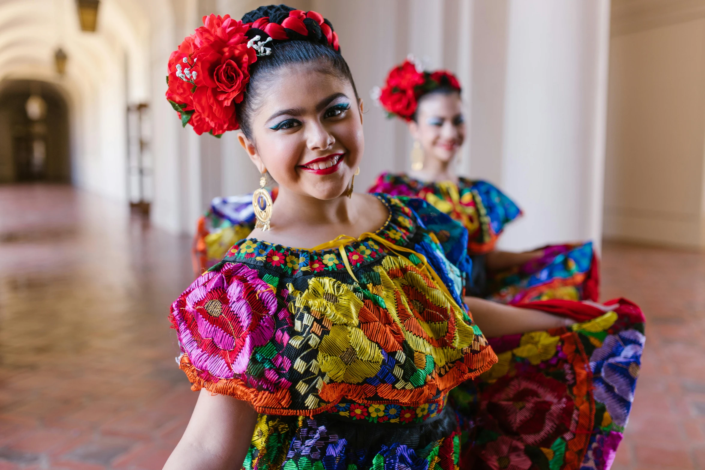 a couple of women in colorful dresses standing next to each other, folklorico, portrait image, promotional image, college