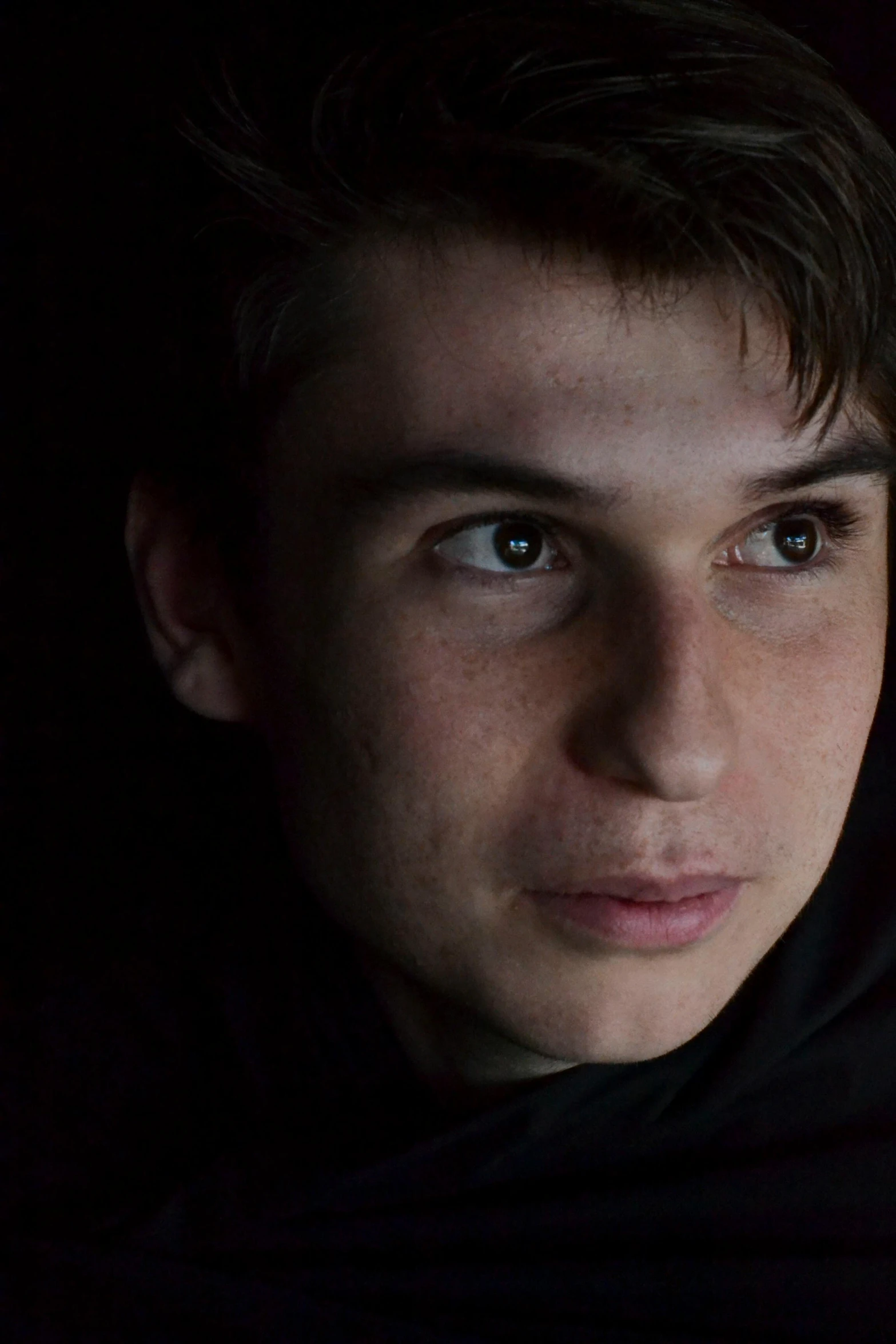 a close up of a person holding a cell phone, an album cover, inspired by Steven James Petruccio, trending on reddit, young man with beautiful face, dark. no text, lovingly looking at camera, ansel ]