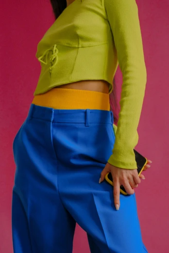 a woman in a yellow top and blue pants, inspired by Yves Klein, trending on pexels, renaissance, ((neon colors)), detail shot, post modernist layering, exposed midriff