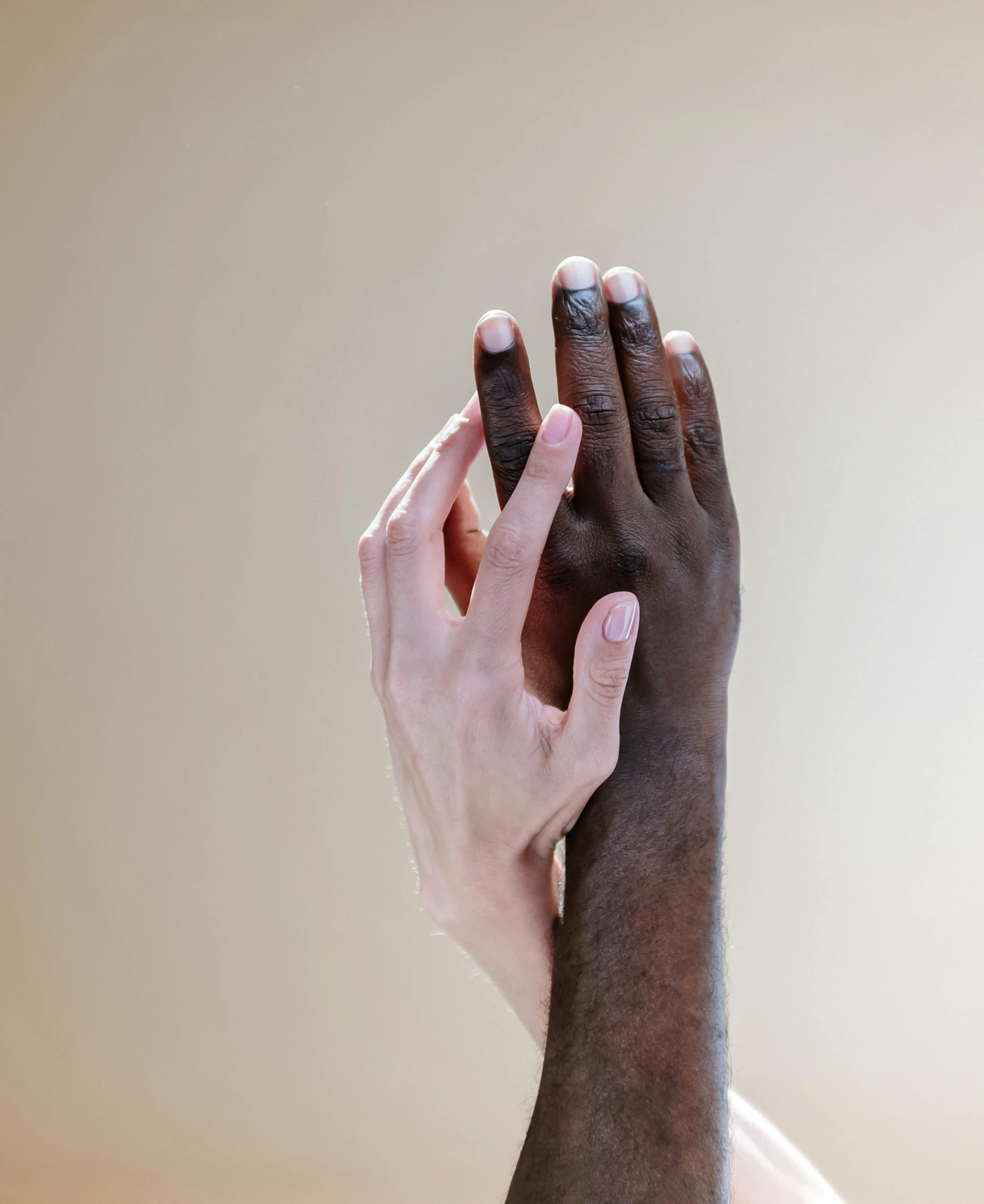 a close up of a person with their hands in the air, by Arabella Rankin, trending on unsplash, renaissance, gradient brown to white, two men hugging, ivory and ebony, panel of black