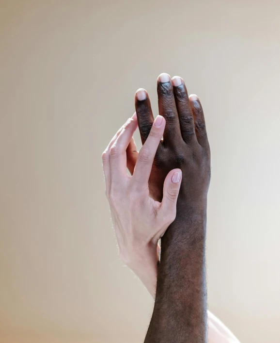 a close up of a person with their hands in the air, by Arabella Rankin, trending on unsplash, renaissance, gradient brown to white, two men hugging, ivory and ebony, panel of black