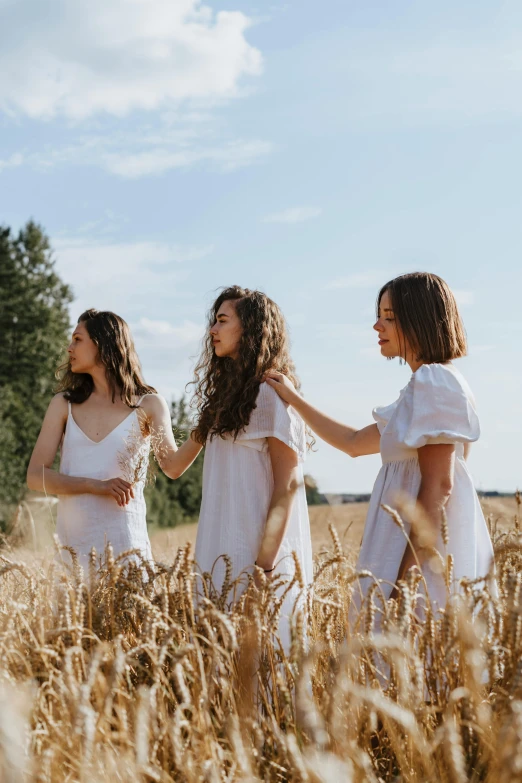 three women in white dresses standing in a wheat field, an album cover, by Julia Pishtar, pexels contest winner, brunettes, college, nordic folk, soft shade