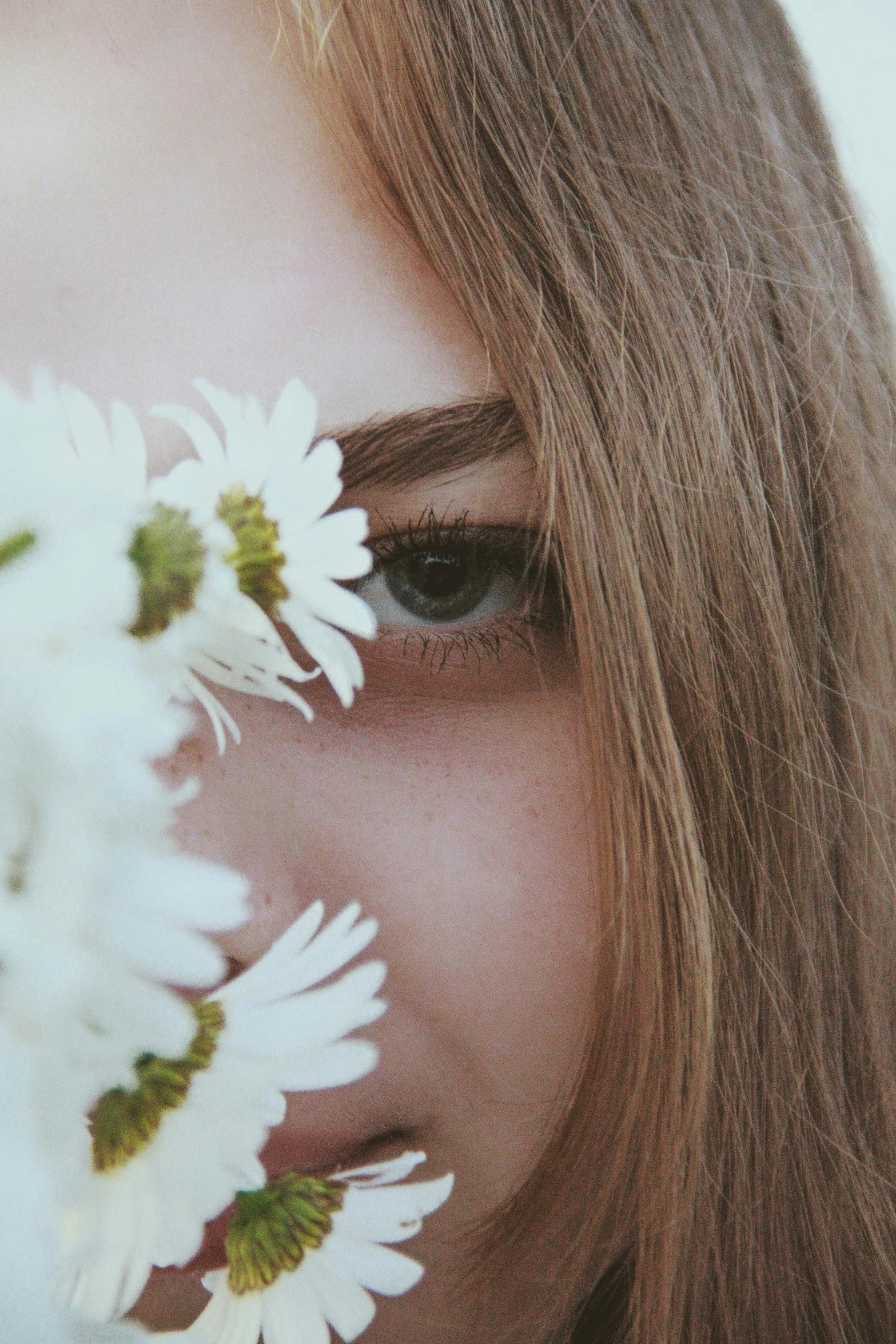 a woman holding a bunch of white flowers in front of her face, trending on unsplash, aestheticism, close - up shot of eyes, girl with brown hair, close-up portrait film still, shot with sony alpha