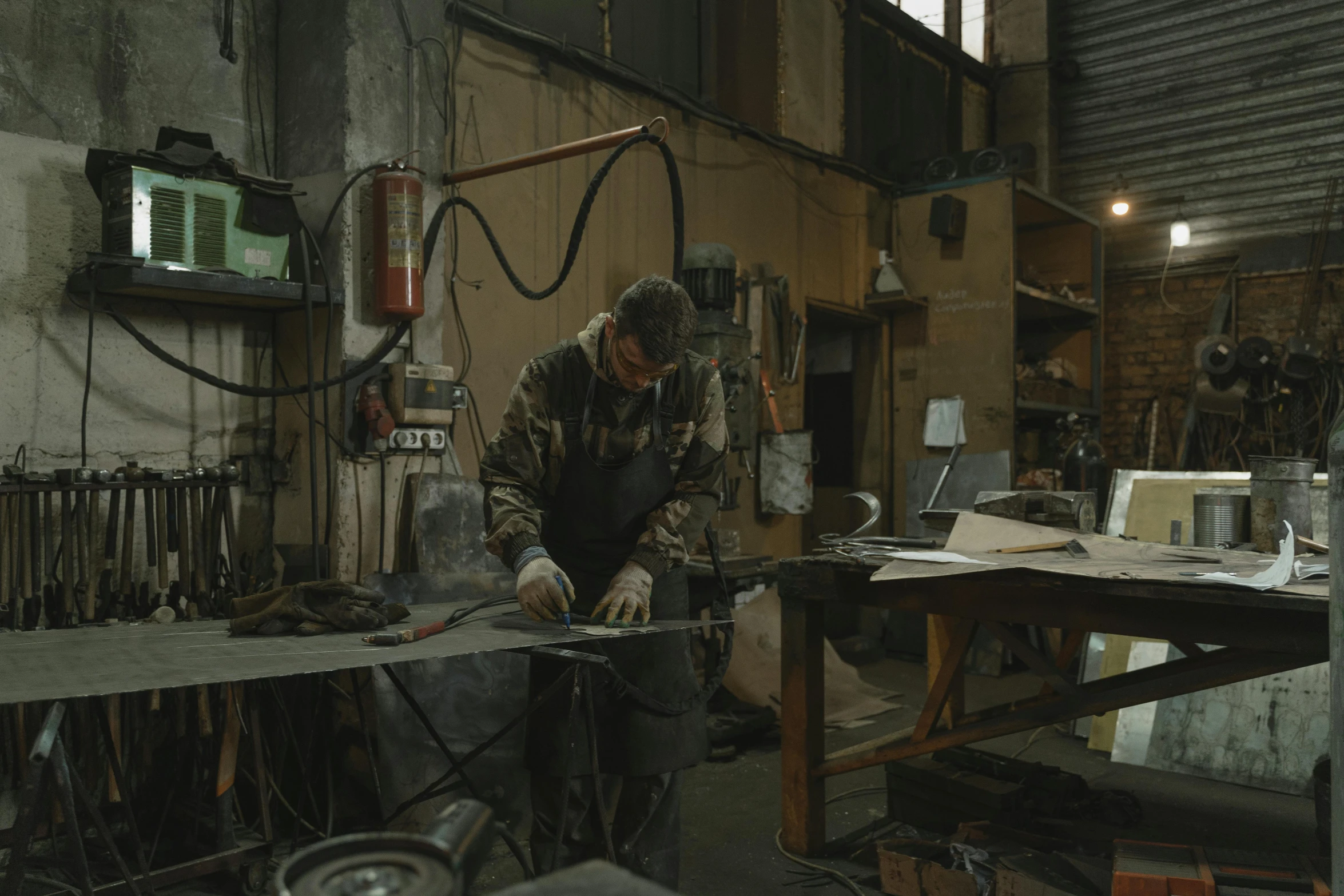 a man working on a piece of metal in a workshop, an album cover, ignant, tv still, worksafe. cinematic, mid body