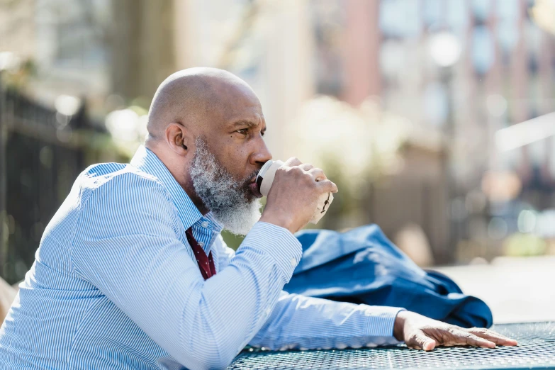 a man with a beard sitting on a bench, a photo, inspired by William H. Mosby, unsplash, mr robert is drinking fresh tea, mike tyson, profile image, sunny day time