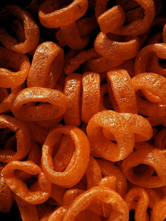 a pile of orange rings sitting on top of a table, cheerios, gritty textured, real sousaphones, thumbnail