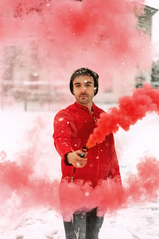 a man standing in the snow holding a red smoke bomb, inspired by Alonso Vázquez, light stubble with red shirt, sovietwave aesthetic, robert sheehan, profile picture 1024px