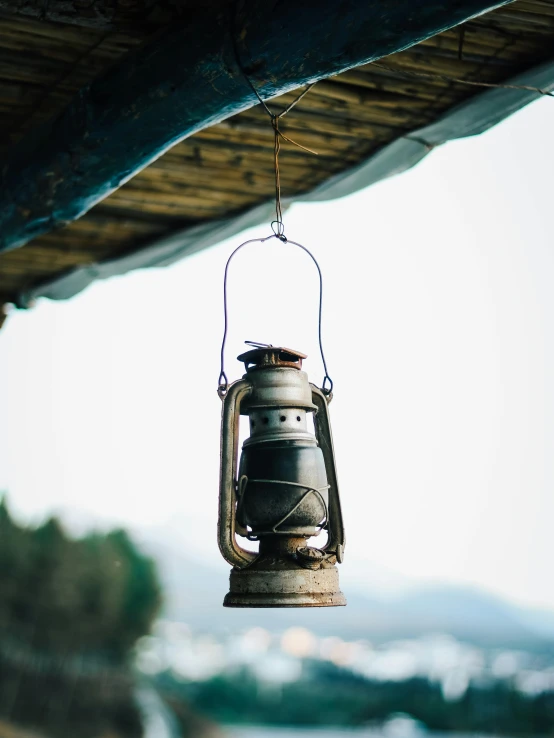 a lantern hanging from a roof over a body of water, unsplash, portrait of a slightly rusty, low quality photo, stacked image