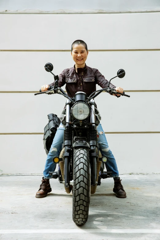 a man sitting on a motorcycle in front of a garage, a portrait, inspired by Hiroshi Honda, pexels contest winner, an asian woman, with two front pockets, plain background, avatar image