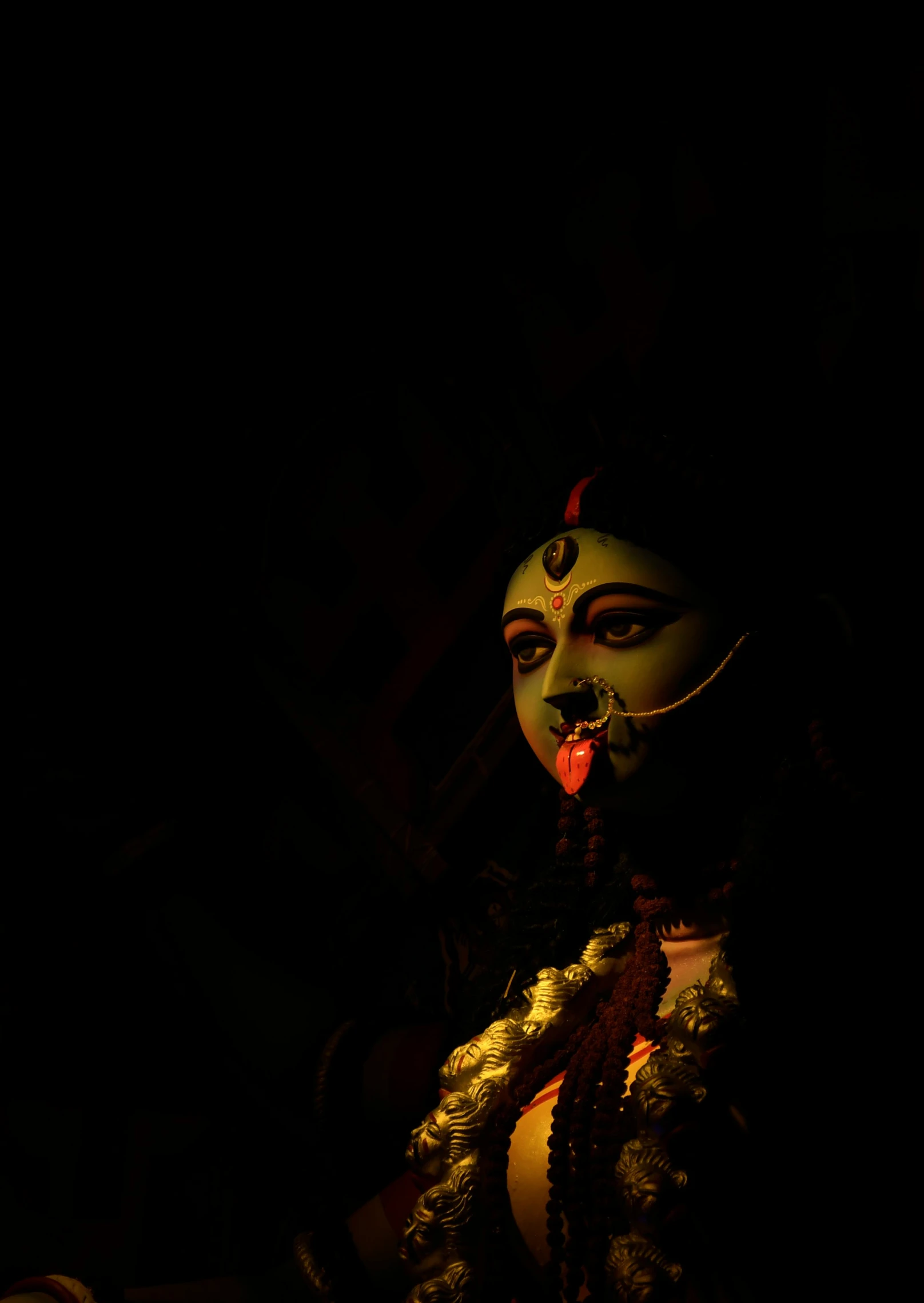 a close up of a statue in the dark, by Sudip Roy, pexels contest winner, bengal school of art, pagan goddess, lips, kali, ✨🕌🌙