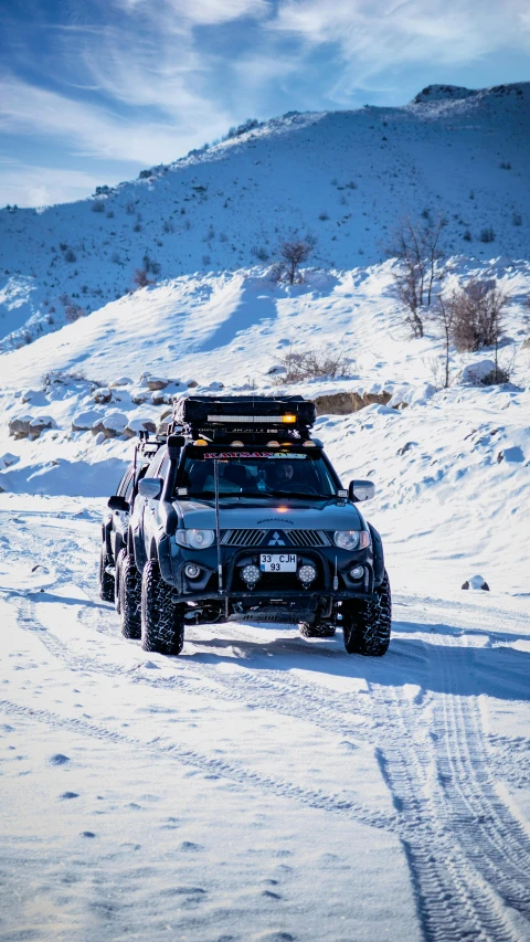 a car driving down a snow covered road, ayanamikodon and irakli nadar, ultra 4k, professional photo, fully armoured