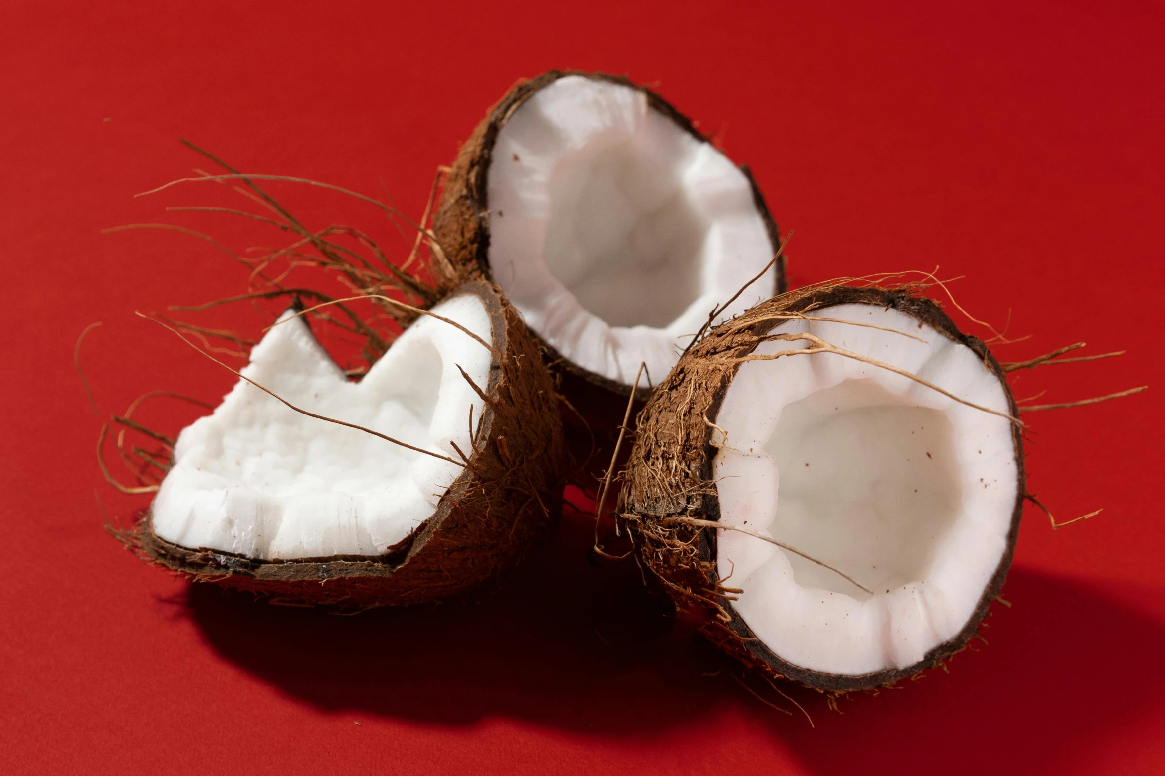 a couple of coconuts sitting on top of a red surface, profile image, epicurious, fan favorite, close-up photo