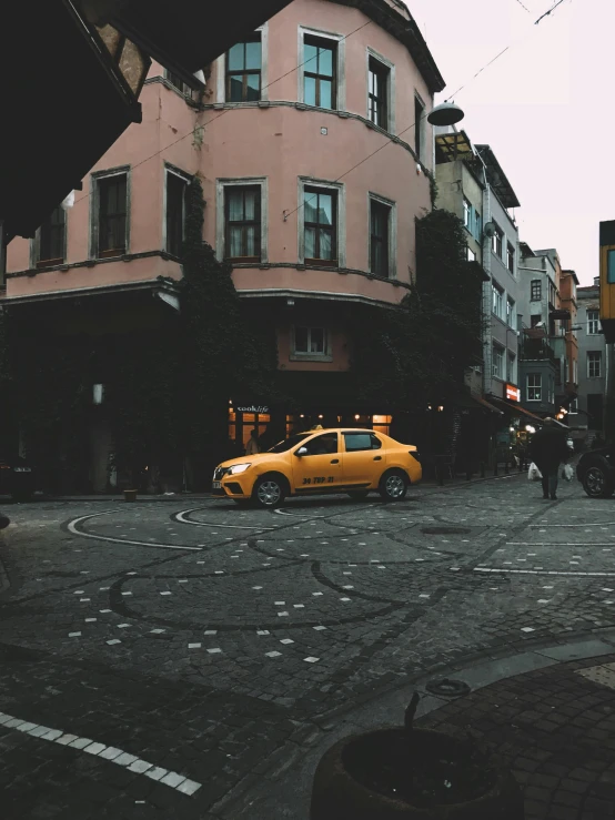 a yellow car driving down a street next to tall buildings, pexels contest winner, hyperrealism, istanbul, trending on vsco, cobblestone streets, panoramic view of girl