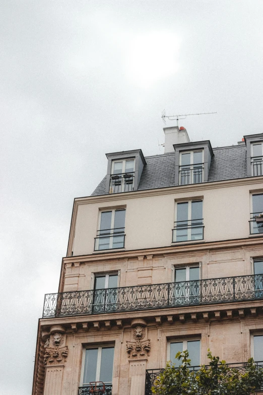 a tall building with a clock on top of it, trending on unsplash, paris school, overcast gray skies, rooftop romantic, crenellated balconies, high resolution photo