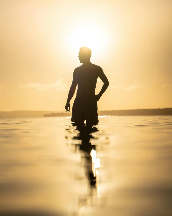 a person standing in the water at sunset, lgbtq, leaked image, male model, insightful
