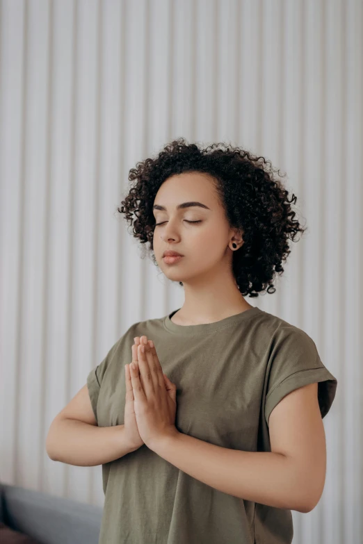 a woman in a green shirt is doing yoga, trending on pexels, renaissance, indian girl with brown skin, praying, calmly conversing 8k, centered in image