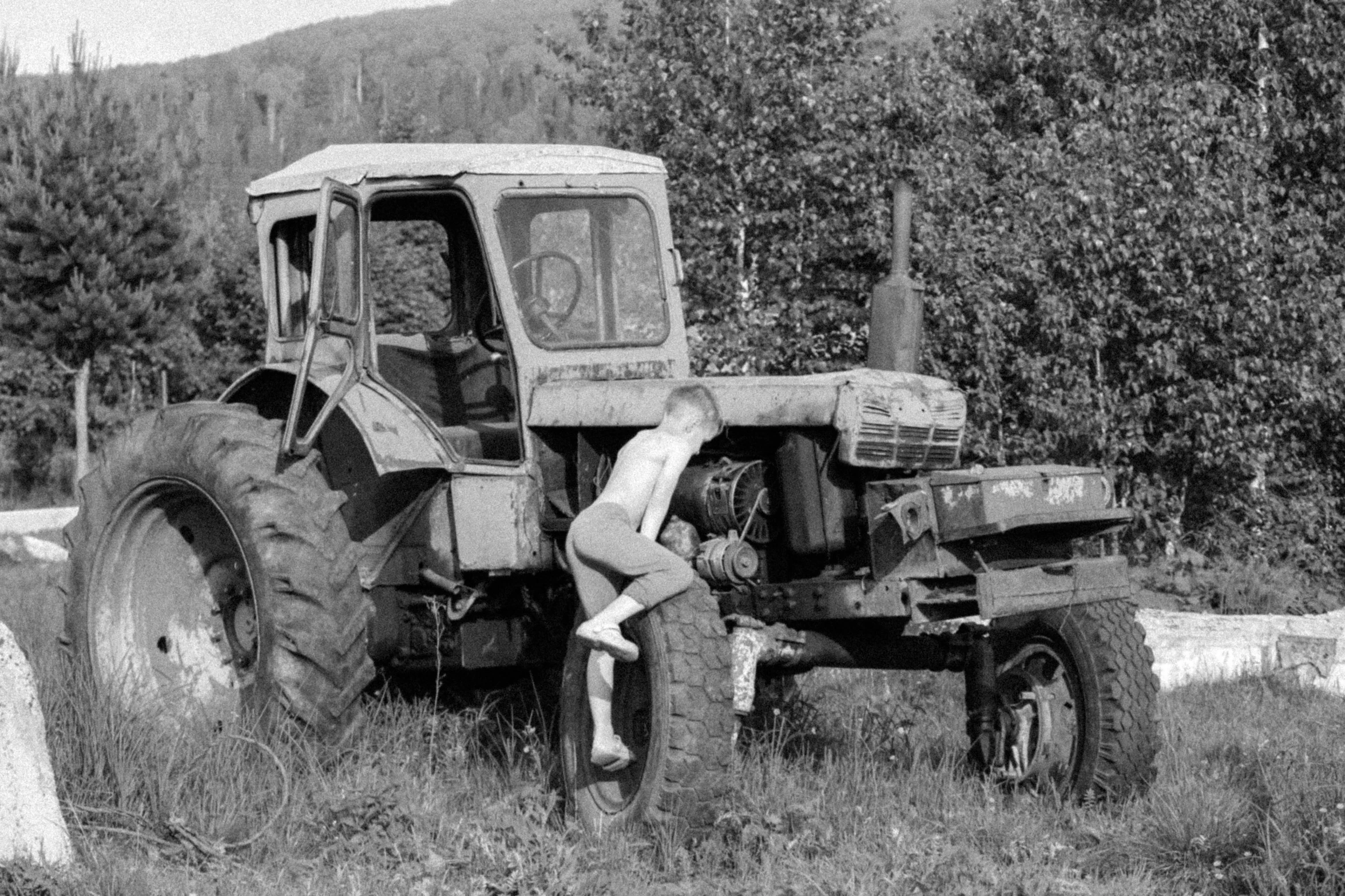 a black and white photo of an old tractor, an album cover, by Eero Järnefelt, figuration libre, naturist, 1968 soviet, childhood, resting after a hard fight