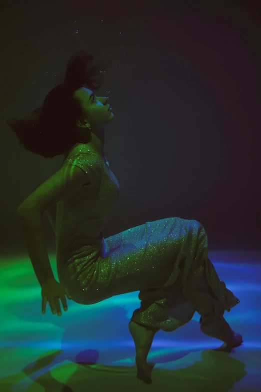 a woman that is sitting down in the water, an album cover, inspired by Bert Stern, unsplash, holography, colored lighting, kneeling at the shiny floor, maria borges, low - angle shot