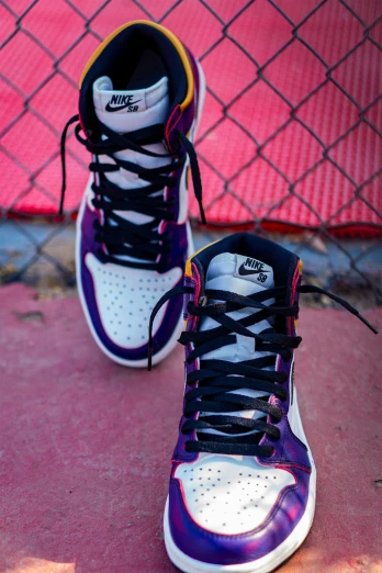 a pair of purple and white sneakers next to a fence, a portrait, inspired by Jordan Grimmer, unsplash, ultra high detail, multi colored, taken with sony alpha 9, air jordan 1 high