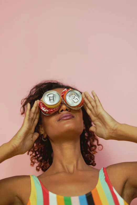 a woman covering her eyes with a pair of glasses, inspired by Dorothy Coke, trending on pexels, pop art, soda cans, deep tan skin, looking upwards, sardine in a can