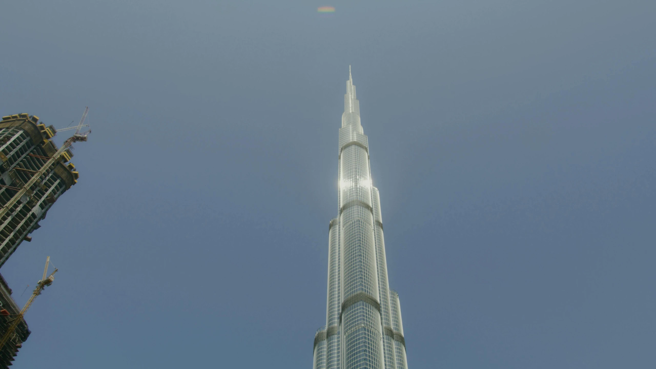 a tall building in the middle of a city, ray tracing global illumination, dubai, pointing to heaven, photorealist