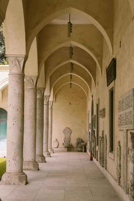 a very long building with a bunch of columns, a marble sculpture, inspired by Luis Paret y Alcazar, romanesque, patio, gallery, tlaquepaque, mosque interior