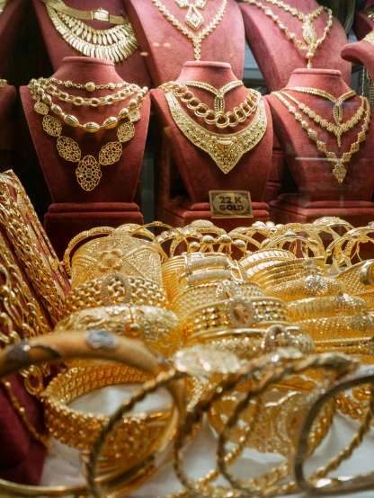 a display case filled with lots of gold jewelry, inside an arabian market bazaar, thumbnail, posing