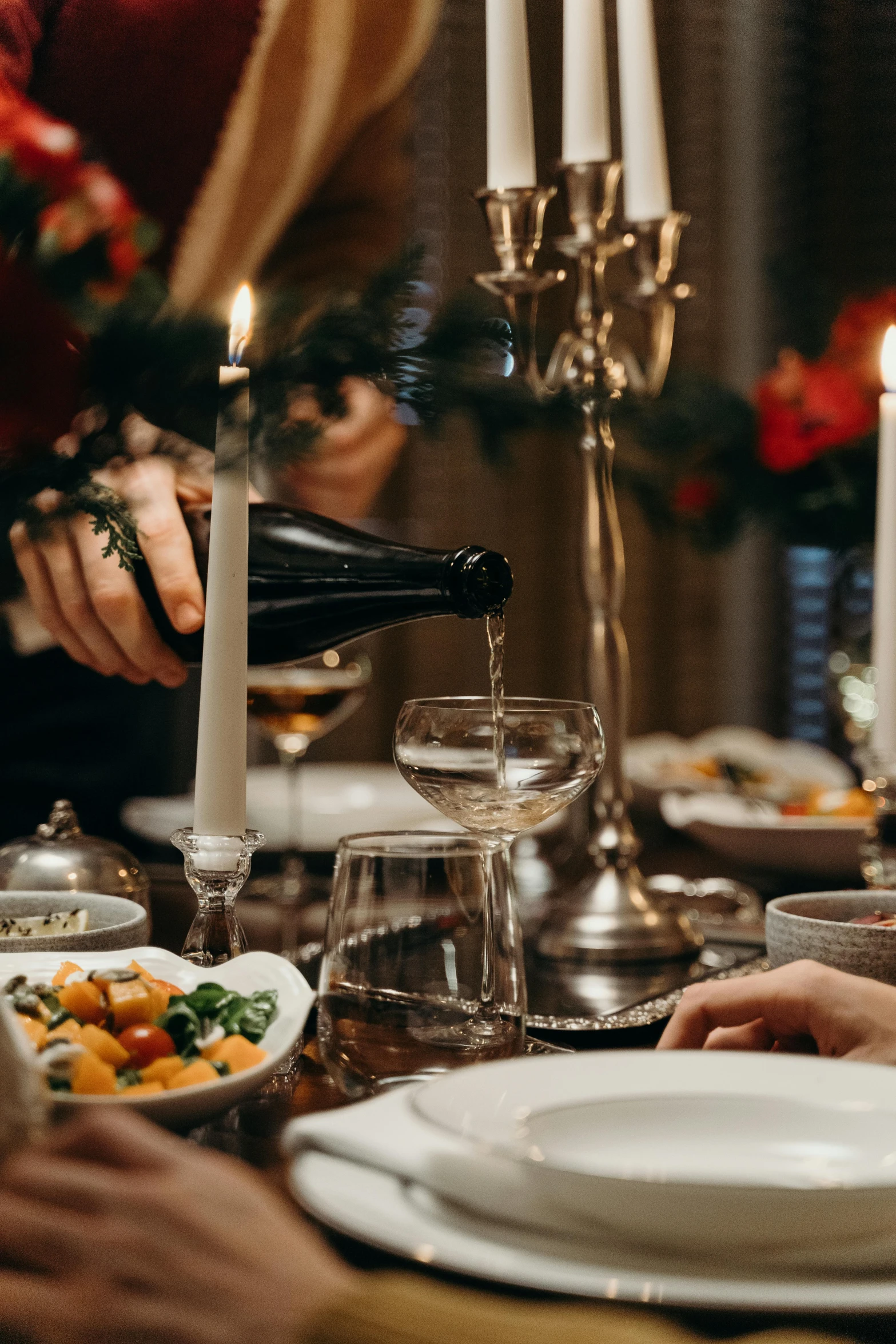 a group of people sitting around a dinner table, white wine bottle, pouring, holiday season, soup