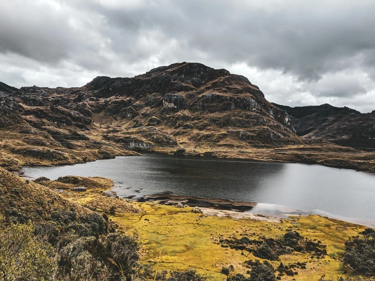 a body of water surrounded by mountains under a cloudy sky, a photo, trending on unsplash, hurufiyya, peruvian looking, 🤠 using a 🖥, autumn, slate